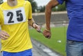 Way of leading blind runner: hand of disabled athlete, on a left, holding hand of healthy one by rope Royalty Free Stock Photo