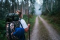 Way of Saint James pilgrim backpacker female going by the path through Eucalyptus forest back view image shoot