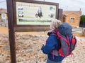 way of st james to Compostela , pilgrim woman reading informative poster