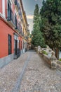 Granada empty narrow streets around Carrera Del Darro. Narrow cobbled streets of Granada in sunshine and blue sky above.