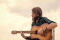 way to relax. brutal handsome man with moustache play guitar. mature musician and singer. casual styled guitarist