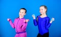 On way to stronger body. Girls exercising with dumbbells. Beginner dumbbells exercises. Children hold dumbbells blue