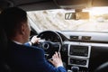 On the way to success. Confident and young businessman in stylish suit is driving his new luxury car and smiling Royalty Free Stock Photo