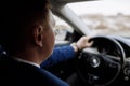 On the way to success. Confident and young businessman in stylish suit is driving his new luxury car and smiling Royalty Free Stock Photo