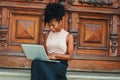 Way to Success. Young African American woman with afro hairstyle wearing sleeveless light color top, black skit, sitting by Royalty Free Stock Photo