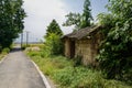Wayside dilapidated brick-framed cottage with earthen wall in we