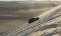 4WD vehicle driving up a sand dune in Khor Al Adaid desert in Qatar Royalty Free Stock Photo