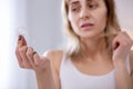 Depressed cheerless woman looking at the tuft of hair