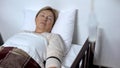 Weak pensioner patient sleeping in hospital bed under drop counter treatment Royalty Free Stock Photo