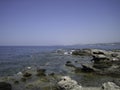 Weak waves gently wash the stones lying on the shallow bottom of the sea rocky shore in good weather