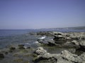 Weak waves gently wash the stones lying on the shallow bottom of the sea rocky shore in good weather