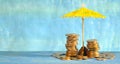 wealth management or rising prices for vacation concept,heap of coins and sun umbrella, free copy space Royalty Free Stock Photo