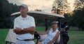 Wealthy golf players resting at golf cart. Sport couple enjoy summer weekend. Royalty Free Stock Photo