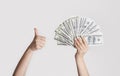 Wealthy woman with money showing thumb up gesture on light background, close up Royalty Free Stock Photo