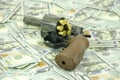 A weapon with load bullets laid down on blurred dollars Royalty Free Stock Photo