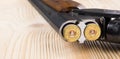 Weapon with two cartridges inside on a wooden background Royalty Free Stock Photo