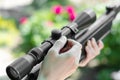 Man sets up the rifle scope. Preparing weapons for shooting. Woman with guns Royalty Free Stock Photo