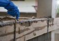 Wear glove hand of industrial bricklayer hold aluminium brick trowel installing mortar wall on construction site