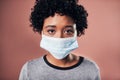 Wear a mask, stop the spread. Studio shot of a young wman wearing a mask against a pink background.