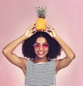 Wear your crown and be sweet about it. Studio shot of a beautiful young woman posing with a pineapple on her head. Royalty Free Stock Photo