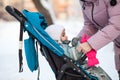 Wearin pink mittens on children hands while walking with stroller in winter cold time, close-up view