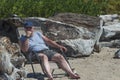 Man lounges in a folding chaise on the beach at Siletz Bay Park, Lincoln City, Oregon