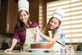 Wearing chef hats and decorating a cake Royalty Free Stock Photo