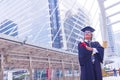 He is wearing graduate is dress and standing and show hand. Royalty Free Stock Photo