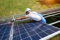 Wearing protective helmet, mounter installing solar panels on roof. Royalty Free Stock Photo