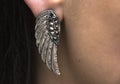 Wearing a silver metal wing earing