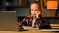 Weary sleepy caucasian young child blonde little lazy tired girl studying routine online elementary educational lesson
