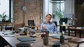 Weary woman entrepreneur looking at table pendulum sitting empty office overtime