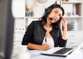 Weary woman with microphone headset at work in office