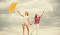 Weather changing. Girls friends with umbrellas cloudy sky background. Ready for any weather. Windy or rainy we are