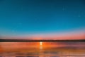 Blue bright starry sky on pink yellow sunset at sea water vawe reflection blurred light full moon moonlight  skyline  nebula natur Royalty Free Stock Photo