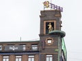 The Weather Girl, movable famous barometer on the roof of the building, girl with a bicycle and boy with umbrella Royalty Free Stock Photo