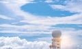 Weather observations radar dome station against blue sky and white fluffy clouds. Aeronautical meteorological observations station Royalty Free Stock Photo