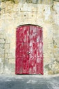 Weather red door in limestone building Royalty Free Stock Photo