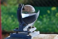 Weather station and the sun in a blue sky reflected in the glass sphere of a beautiful heliograph o Royalty Free Stock Photo