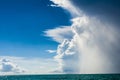 Weather changing in the Tropes, fast gathering cumulonimbus clouds over calm sea. Dangerous situation Royalty Free Stock Photo