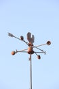 Weather Vane compass over house roof against blue sky background Royalty Free Stock Photo