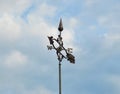 Weather Vane Compass Pointing West East Directions on Blue Sky