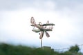 Weather vane in form of an old rusty biplane, at a back angle, with propellers not moving Royalty Free Stock Photo