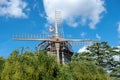 Weather vane on old windmill qt blue sky background