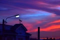 Weather vane at sunrise with bright colors in clouds