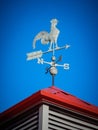 Weather vane on red roof