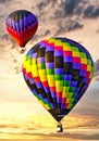 Two colorful hot air balloons ascending into a beautiful sky at sunrise