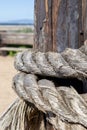 Weatherd rope tied around wood post