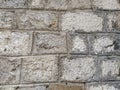 Weathered aged stone masonry of old house. Ancient brick wall background. Old uneven scratched stone bricks texture. Turkish