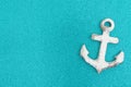 Weathered anchor on a turquoise glitter background